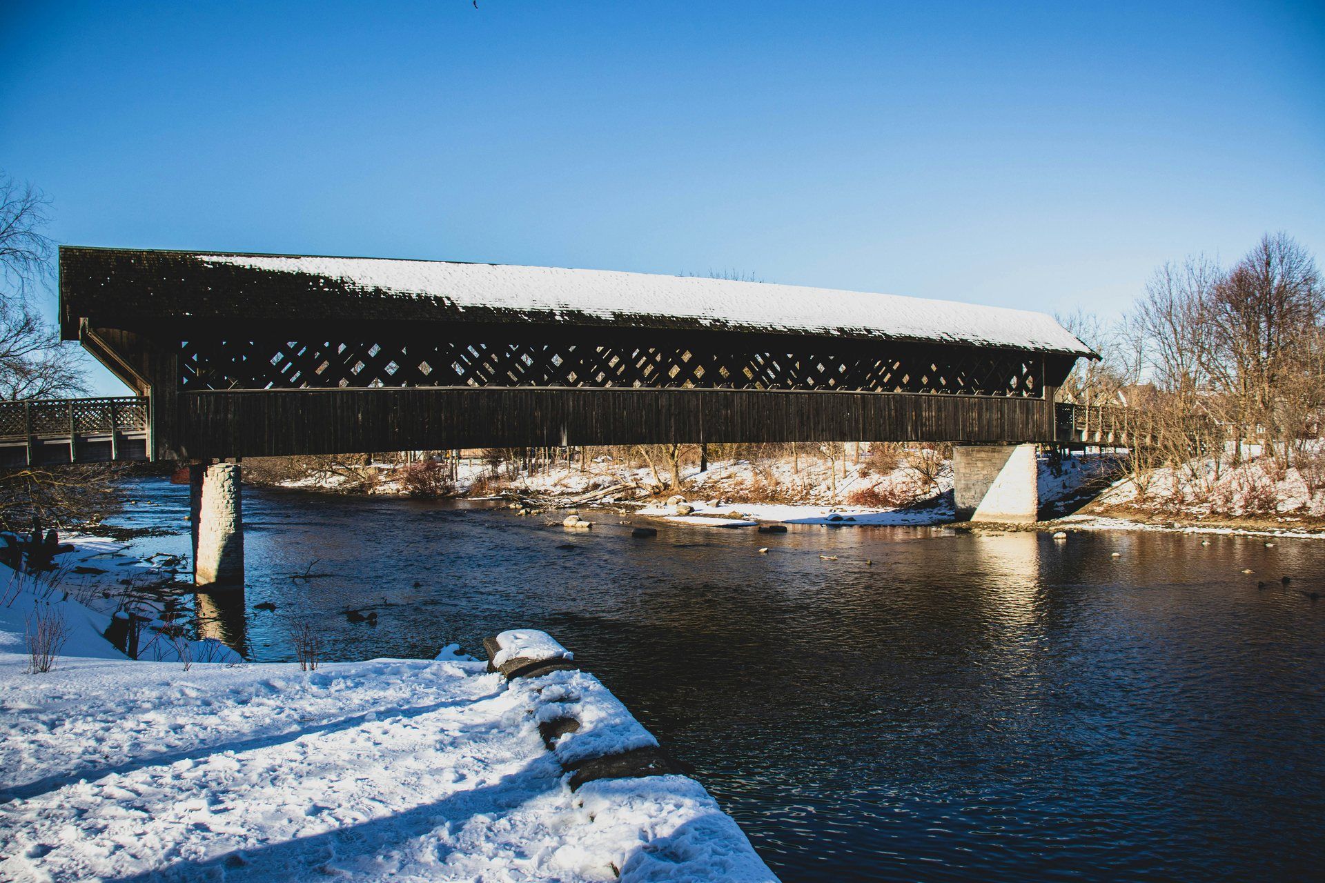 Wooden covered footbridge over the Speed River in Guelph on a sunny winter day